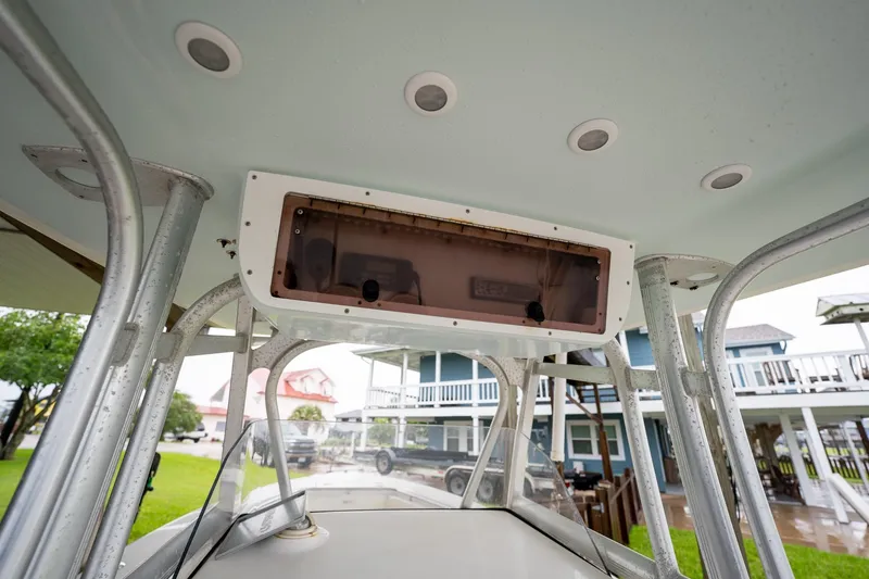 Slide: The Image of 2007 Sea Hunt Triton 290 boat console with overhead storage and outdoor background. - 27