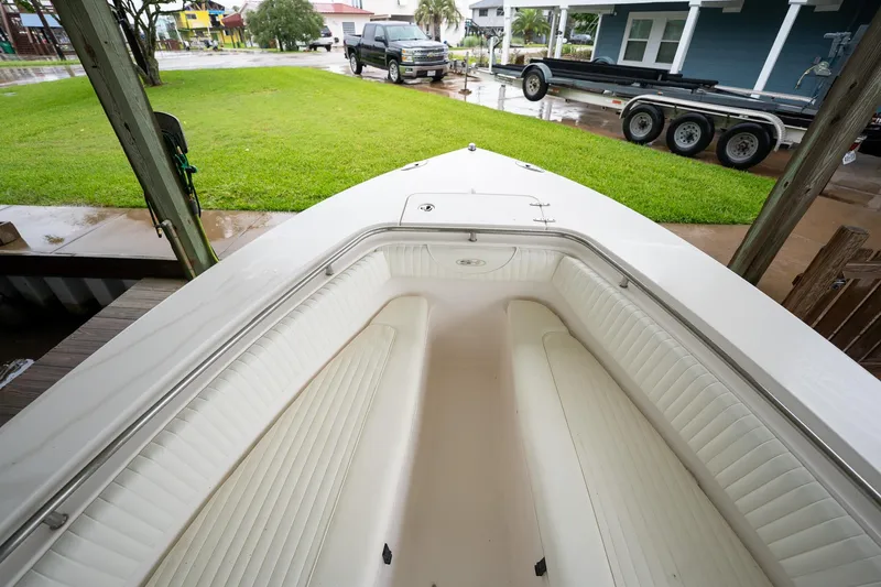 Slide: The Image of 2007 Sea Hunt Triton 290 boat with white interior, parked near a lawn and trailer. - 31