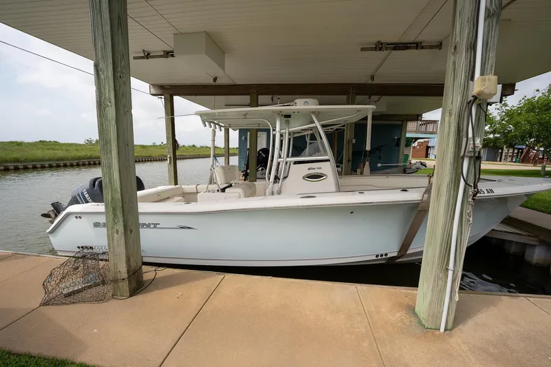 Slide: The Image of 2007 Sea Hunt Triton 290 boat docked under a covered structure by a canal. - 5