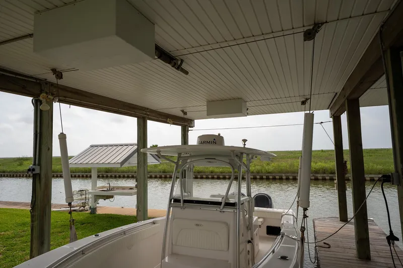 Slide: The Image of 2007 Sea Hunt Triton 290 docked under covered boathouse by a canal. - 9
