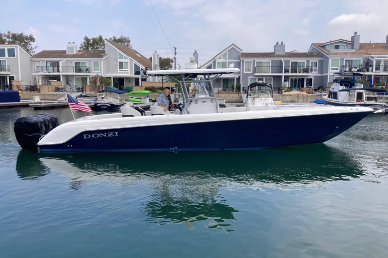Slide: The Image of 2011 Donzi 38 ZFX Open boat docked in a marina, with waterfront homes in the background. - 1
