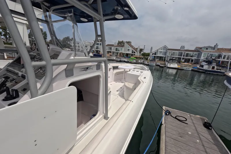 Slide: The Image of 2011 Donzi 38 ZFX Open boat docked in a marina, showcasing sleek design and controls. - 10