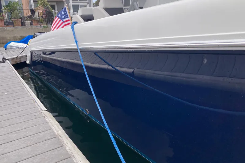 Slide: The Image of 2011 Donzi 38 ZFX Open boat docked, featuring sleek blue and white design. - 12