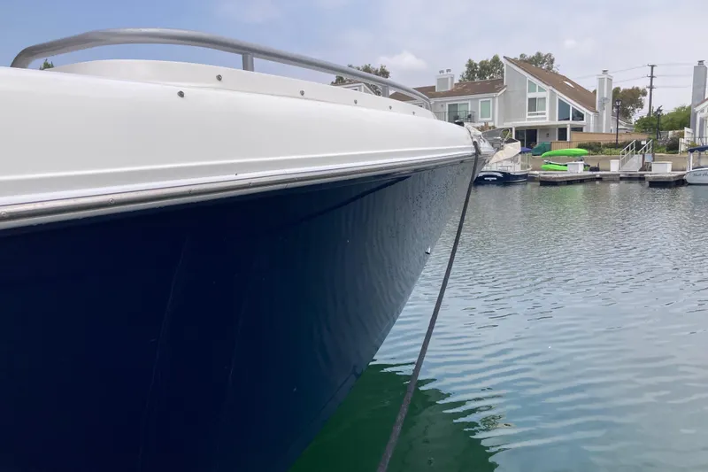 Slide: The Image of 2011 Donzi 38 ZFX Open boat docked in a serene waterfront setting. - 13