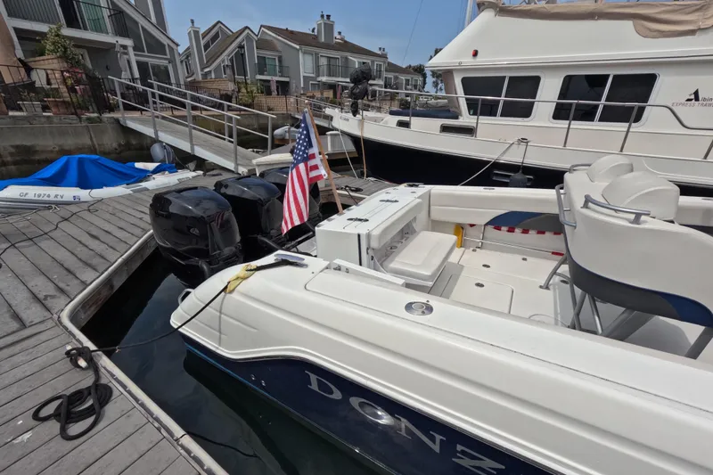 Slide: The Image of 2011 Donzi 38 ZFX Open boat docked with American flag, dual engines visible. - 14