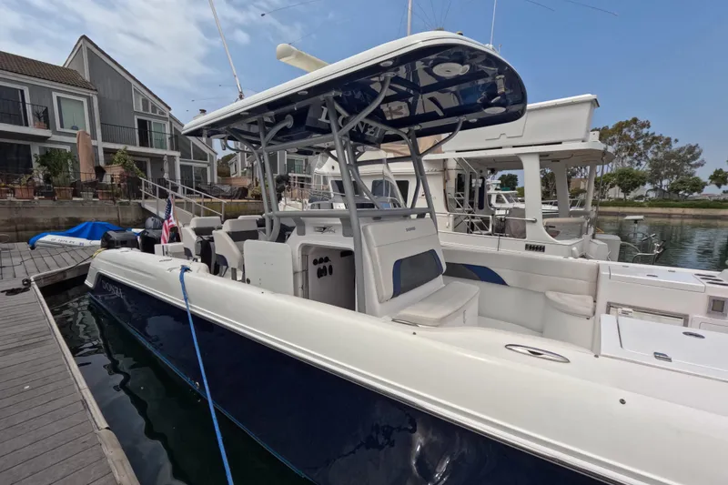 Slide: The Image of 2011 Donzi 38 ZFX Open boat docked at marina, featuring sleek design and spacious seating. - 15