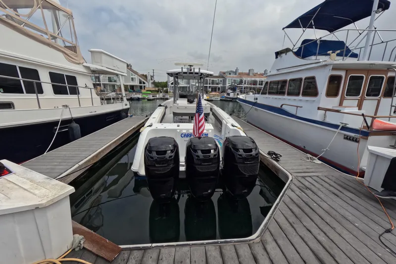 Slide: The Image of 2011 Donzi 38 ZFX Open docked with triple outboard engines in a marina. - 16