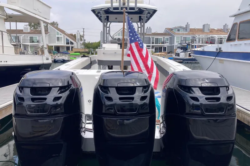 Slide: The Image of 2011 Donzi 38 ZFX Open boat with triple engines and American flag at marina. - 18
