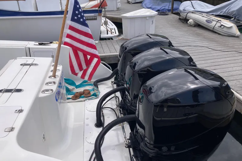 Slide: The Image of 2011 Donzi 38 ZFX Open boat with triple outboard engines and American flag at dock. - 20