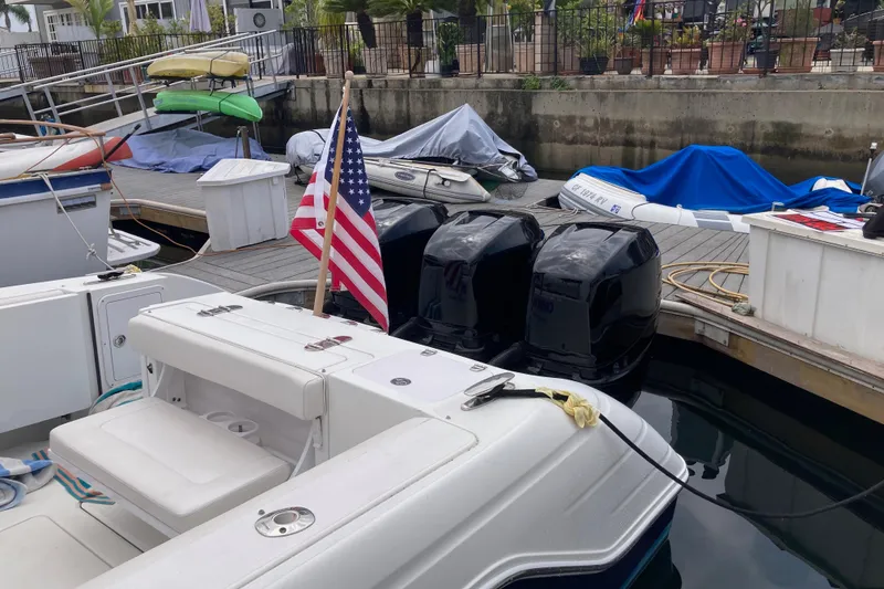 Slide: The Image of 2011 Donzi 38 ZFX Open boat docked with American flag and triple outboard engines. - 21