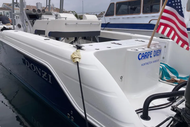 Slide: The Image of 2011 Donzi 38 ZFX Open boat docked, displaying "Carpe Diem" and American flag. - 24