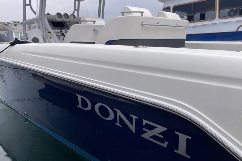 Slide: The Image of 2011 Donzi 38 ZFX Open boat docked, showcasing sleek design and branding. - 25