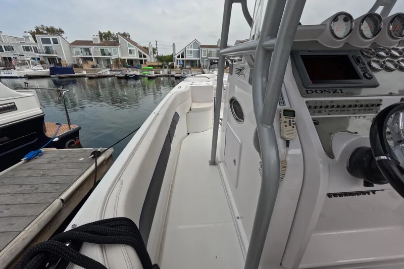 Slide: The Image of 2011 Donzi 38 ZFX Open boat docked, showcasing sleek design and modern controls. - 33