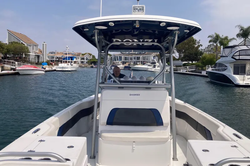 Slide: The Image of 2011 Donzi 38 ZFX Open boat cruising in a marina with waterfront homes. - 35
