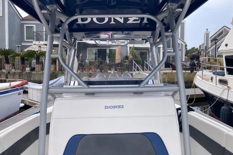 Slide: The Image of 2011 Donzi 38 ZFX Open boat docked at a marina, showcasing sleek design and structure. - 36