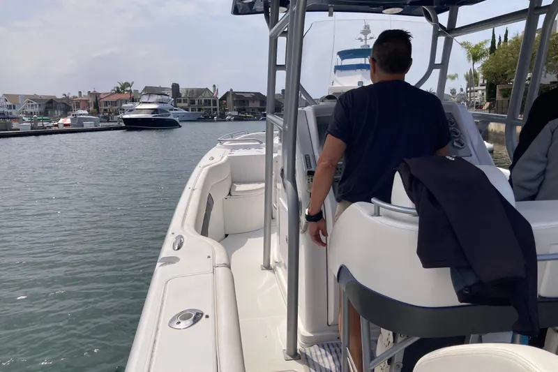 Slide: The Image of 2011 Donzi 38 ZFX Open boat cruising in a marina with waterfront homes. - 41