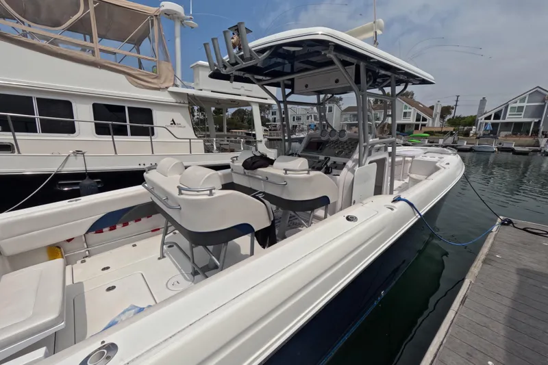 Slide: The Image of 2011 Donzi 38 ZFX Open boat docked at marina, featuring spacious seating and control area. - 9