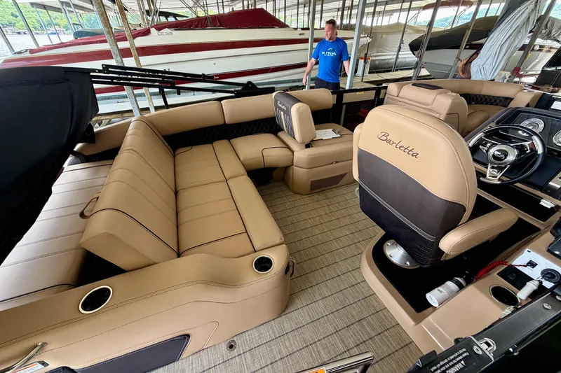 Slide: The Image of 2023 Barletta Lusso 23U pontoon boat interior with luxurious tan seating and modern dashboard. - 28