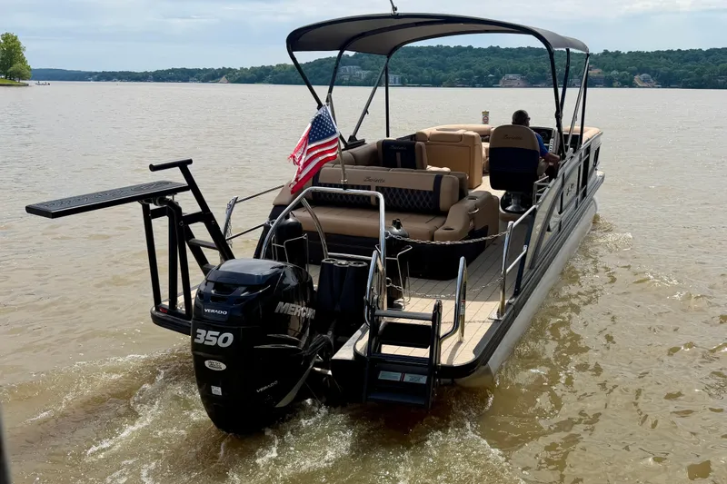Slide: The Image of 2023 Barletta Lusso 23U pontoon boat cruising on a lake with American flag. - 3