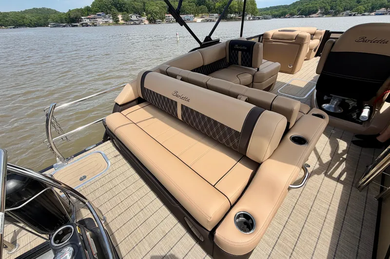 Slide: The Image of 2023 Barletta Lusso 23U pontoon boat interior with luxurious seating on a scenic lake. - 31