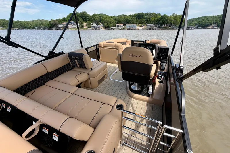 Slide: The Image of 2023 Barletta Lusso 23U pontoon boat interior with luxurious seating on a scenic lake. - 35