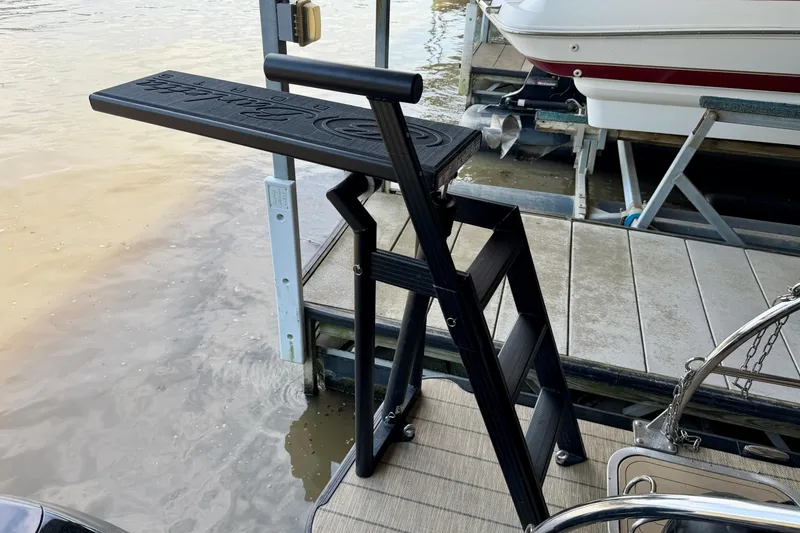Slide: The Image of Dock ladder beside a 2023 Barletta Lusso 23U boat, near water. - 37