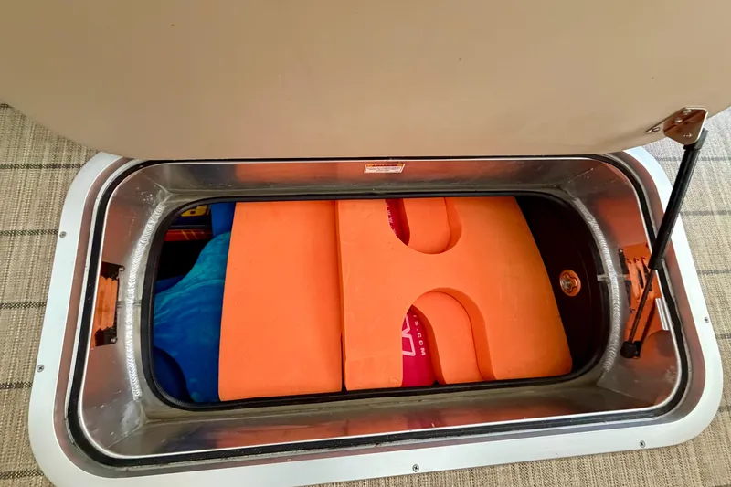 Slide: The Image of Storage compartment in 2023 Barletta Lusso 23U boat with orange flotation devices. - 44