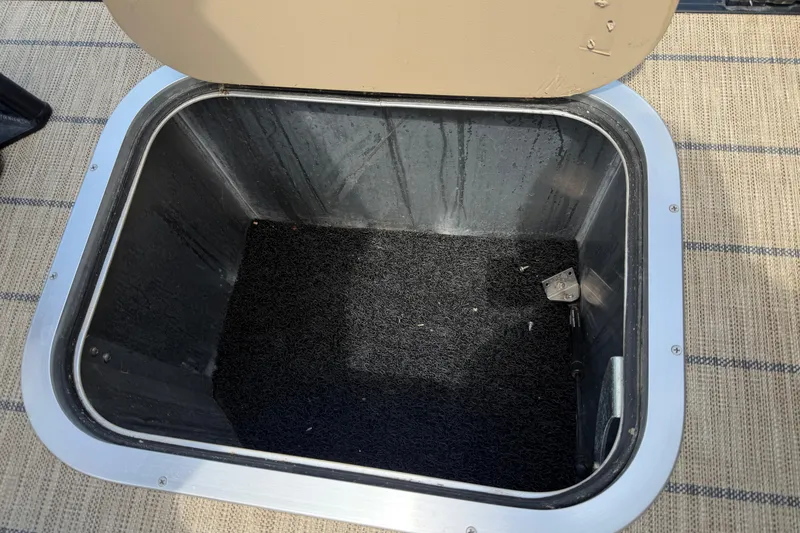 Slide: The Image of Open storage compartment on 2023 Barletta Lusso 23U pontoon boat, featuring carpeted interior. - 49
