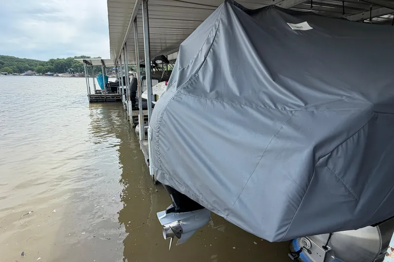 Slide: The Image of Covered 2023 Barletta Lusso 23U pontoon boat docked by a lakeside. - 8