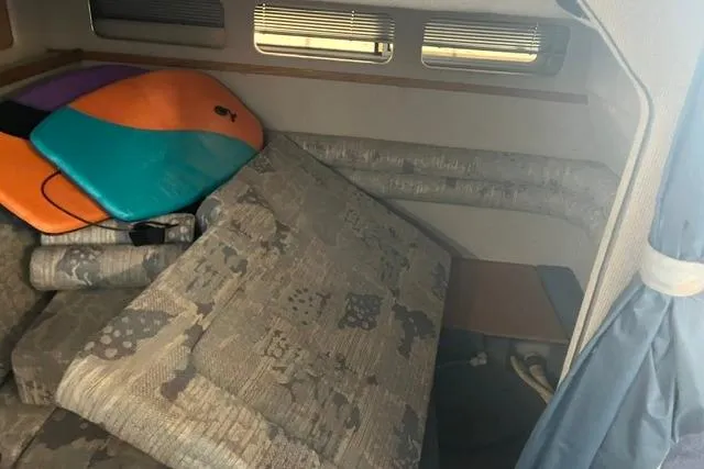 Slide: The Image of Interior cabin of 1993 Sea Ray Sundancer 330 with colorful surfboards and patterned cushions. - 11