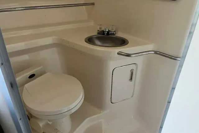 Slide: The Image of 1993 Sea Ray Sundancer 330 bathroom with toilet, sink, and storage compartment. - 13
