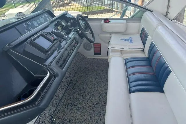 Slide: The Image of 1993 Sea Ray Sundancer 330 cockpit with steering wheel, control panel, and cushioned seating. - 7