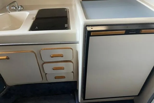Slide: The Image of 1993 Sea Ray Sundancer 330 galley with sink, stove, and refrigerator. - 8