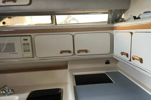 Slide: The Image of Interior of a 1993 Sea Ray Sundancer 330 yacht kitchen with cabinets and appliances. - 9