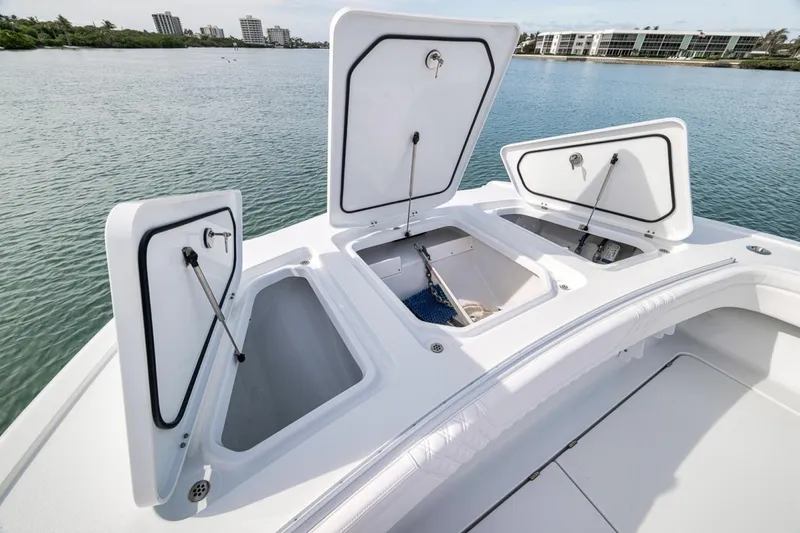 Slide: The Image of 2024 Costa Custom Boats 34SV storage compartments open on deck, overlooking calm waters. - 18