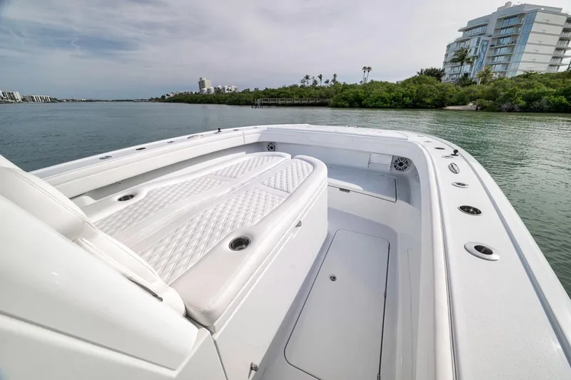 Slide: The Image of 2024 Costa Custom Boats 34SV on calm water, featuring luxurious white seating and sleek design. - 21