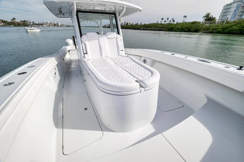 Slide: The Image of 2024 Costa Custom Boats 34SV luxury deck with white seating on calm water. - 22