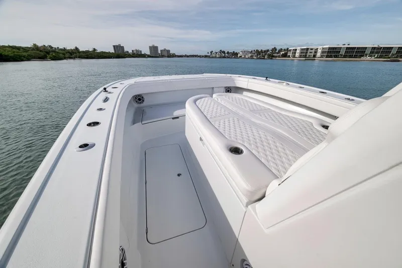 Slide: The Image of 2024 Costa Custom Boats 34SV, luxurious deck view, white seating, calm waters, modern design. - 24