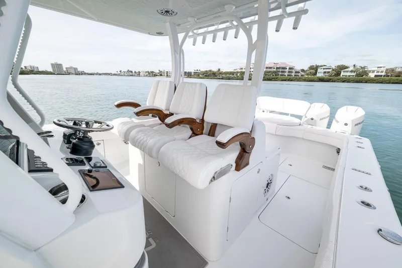 Slide: The Image of 2024 Costa Custom Boats 34SV interior with luxurious seating and modern helm on calm waters. - 26