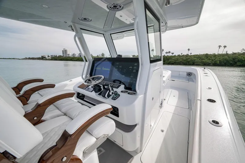 Slide: The Image of 2024 Costa Custom Boats 34SV helm with modern controls and luxurious seating on calm waters. - 31