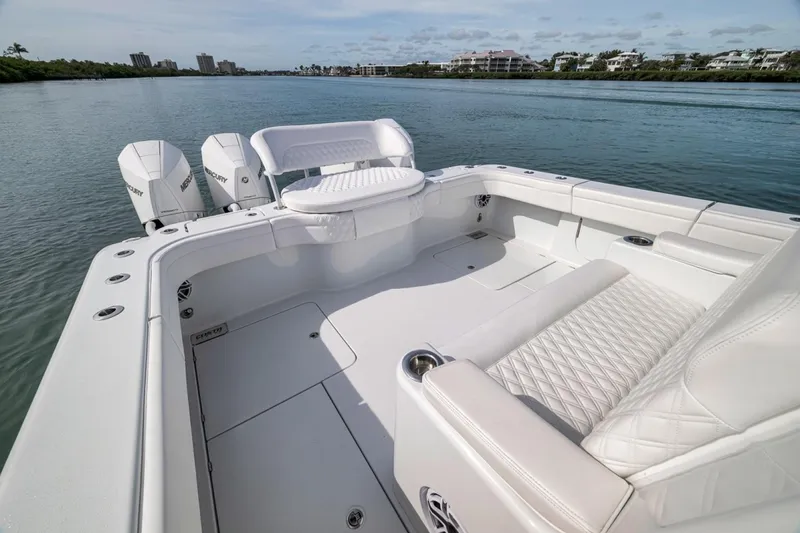 Slide: The Image of 2024 Costa Custom Boats 34SV with luxurious seating and triple Mercury engines on calm water. - 34