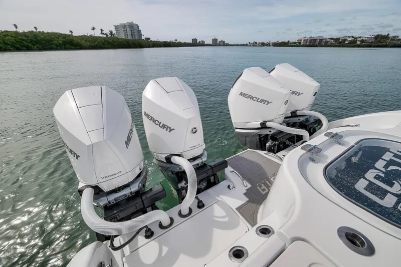 Slide: The Image of 2024 Costa Custom Boats 34SV with four Mercury outboard engines on a serene waterway. - 39