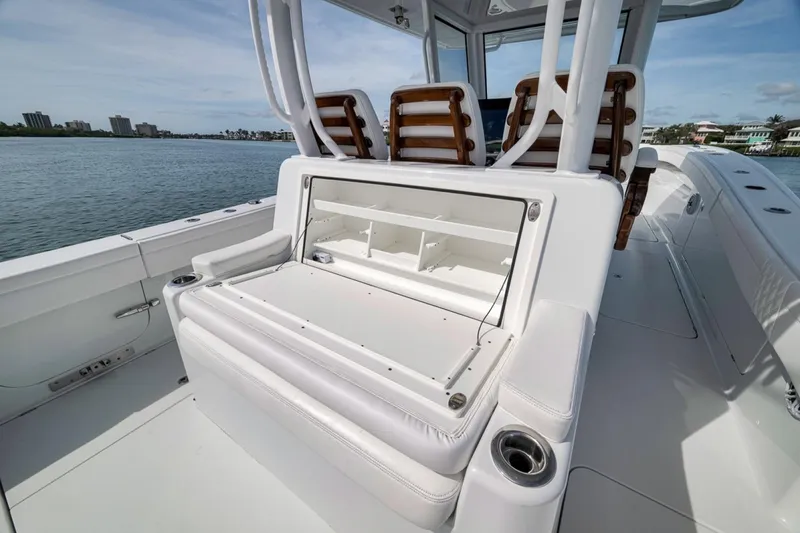 Slide: The Image of 2024 Costa Custom Boats 34SV interior with seating and storage, docked by the water. - 42