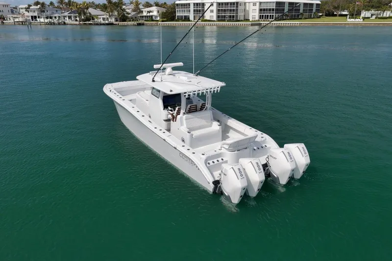 Slide: The Image of 2024 Costa Custom Boats 34SV on calm water, featuring triple outboard engines. - 7