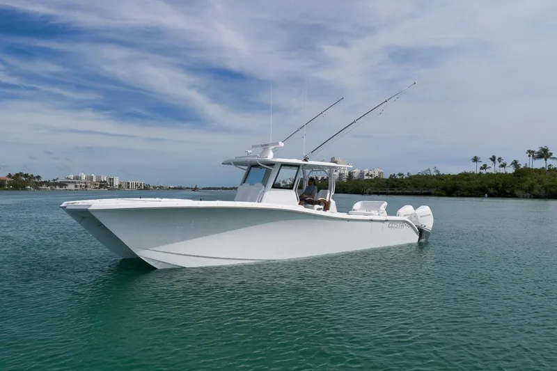 Slide: The Image of 2024 Costa Custom Boats 34SV on calm water, showcasing sleek design and fishing rods. - 9