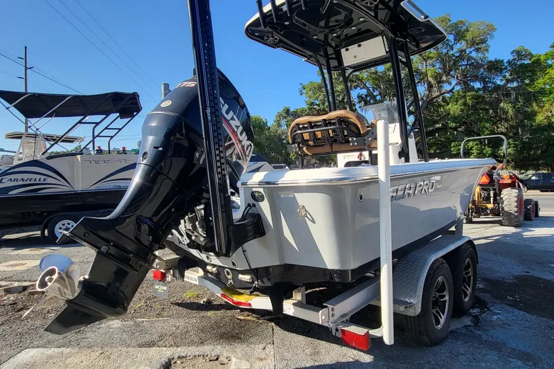 Slide: The Image of 2019 Sea Pro 208 Bay boat on trailer with Suzuki outboard motor, parked outdoors. - 3