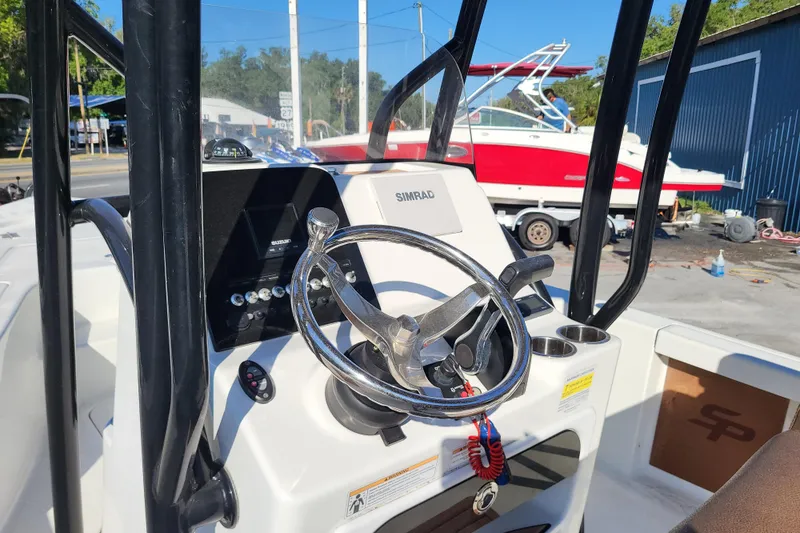 Slide: The Image of 2019 Sea Pro 208 Bay boat dashboard with steering wheel and Simrad display. - 4
