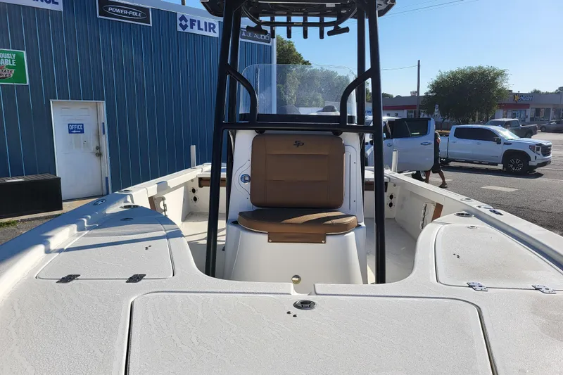 Slide: The Image of 2019 Sea Pro 208 Bay boat interior with seating and console, parked outdoors. - 7