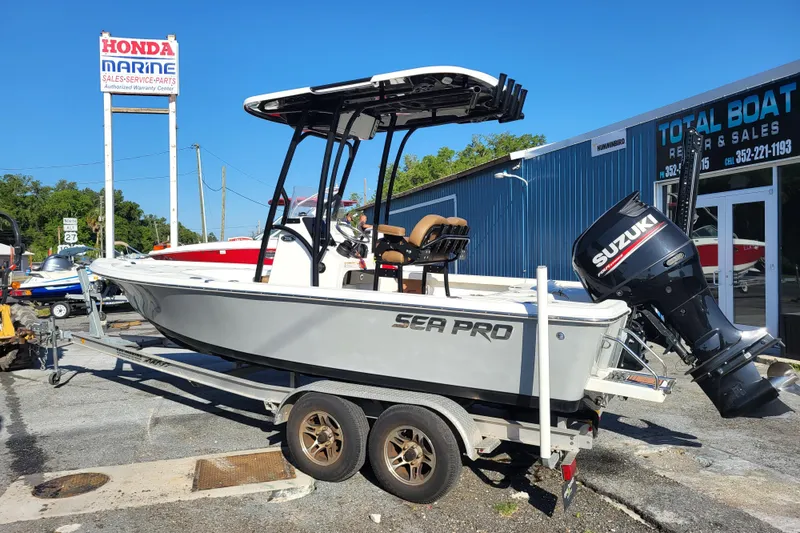 Slide: The Image of 2019 Sea Pro 208 Bay boat on trailer, featuring Suzuki outboard motor, at marine dealership. - 9