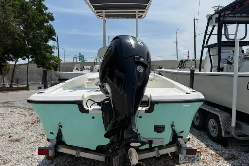 Slide: The Image of 2017 Mako 19 CPX boat with outboard motor on trailer, parked outdoors. - 5